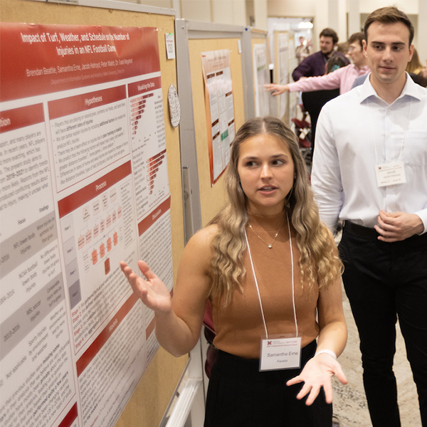 student presenting their poster at the research forum